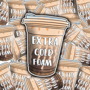May include: A sticker design featuring a brown and white coffee cup with the text "EXTRA COLD FOAM" in white. The sticker is surrounded by other coffee cups with the same text.