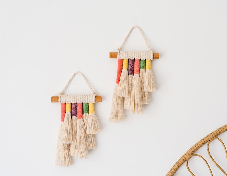 Close up view of two rainbow mini wall hangings