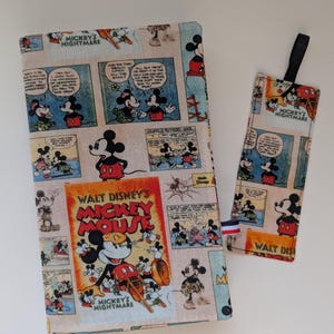 Peut inclure: Un protège-livre et un marque-page assortis avec un motif de bande dessinée vintage de Mickey Mouse. Le motif comprend des cases de bandes dessinées "Mickey's Nightmare" et "Walt Disney's Mickey Mouse". Le marque-page a un ruban noir attaché.