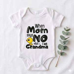 May include: White baby onesie with the text "When Mom says NO I ask Grandma" in black. A yellow cartoon chick is next to the word "NO". The onesie has short sleeves and a snap closure.