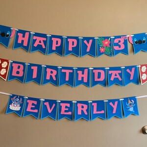Puede incluir: Una pancarta azul y rosa con las palabras "Happy 3rd Birthday Everly" y personajes de Stitch. La pancarta est&aacute; enhebrada en una cuerda blanca.