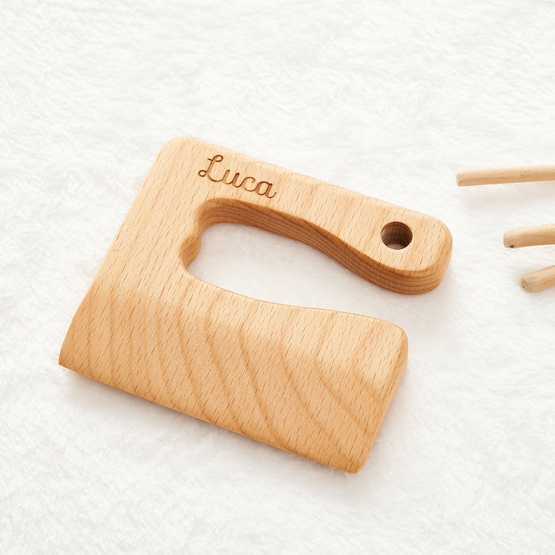 May include: A wooden cutting board with a heart-shaped cutout and a handle. The board is engraved with the name "Luca".