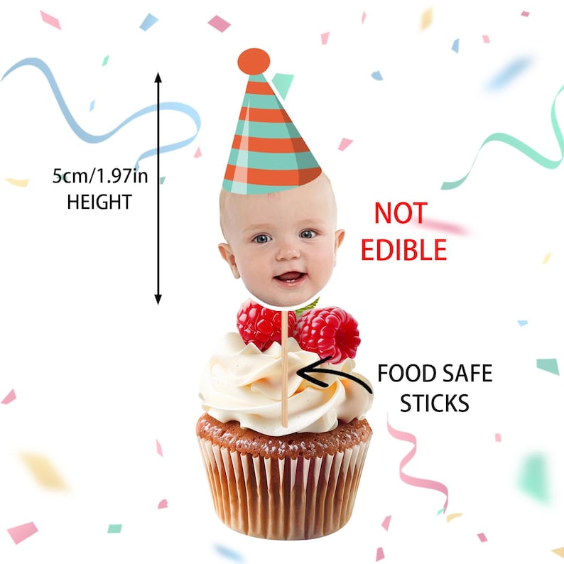 May include: A cupcake with white frosting, topped with raspberries and a baby face cake topper wearing a party hat. The topper is 5cm (1.97in) tall. Text reads "NOT EDIBLE" and "FOOD SAFE STICKS".