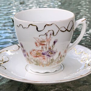 Antique Footed Teacup and Saucer White with Orange Purple Hand Painted Flowers Embossed Freeform Gold Ribbon Decoration