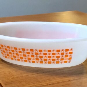 May include: White oval baking dish with an orange and white geometric pattern. The pattern features squares and circles.