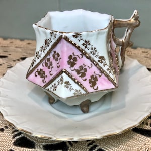 Demitasse Teacup & Saucer Antique 4 Footed White w/Painted Gold Flowers w/Pink Background in Hexagon Shape Made in Germany