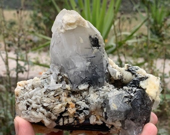 Esemplare di cristallo di quarzo con rutilo nero, tormalina, feldspato e muscovite