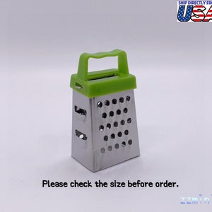 Può includere: Un piccolo grattugia manuale verde e argento con un manico. La grattugia ha una forma rettangolare e una griglia di fori. Si prega di controllare le dimensioni prima di ordinare.