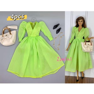 May include: A set of four doll accessories, including a lime green dress with puffed sleeves, a white handbag with a bow, a gold chain necklace, and a pair of black heels. The set is labeled "4pcs".