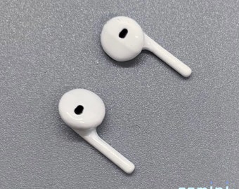 May include: Two white earbud tips with a small hole in the center. The tips have a small stem extending from the side.