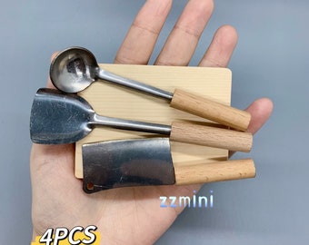 May include: A set of four miniature kitchen tools on a wooden cutting board. The set includes a small ladle, a spatula, a chef's knife, and a wooden cutting board. The tools are made of metal and have wooden handles. The set is labeled "4PCS" and "zzmini".