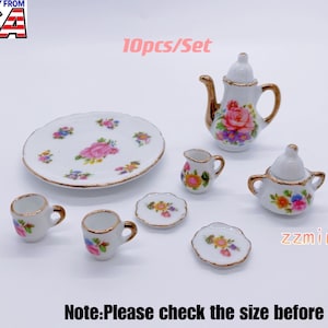 Pode incluir: Um conjunto de chá de porcelana de 10 peças com um design floral. O conjunto inclui uma chaleira, um jarro de creme, um açucareiro, duas chávenas e dois pires.