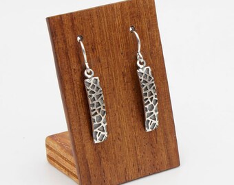 Narrow earring with texture and low relief from the TRENCADIS collection