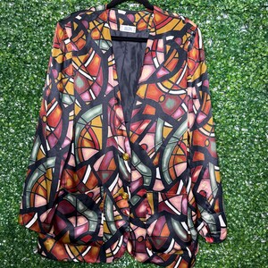 May include: A black satin blazer with a colourful stained glass pattern. The blazer has a button closure and two pockets.