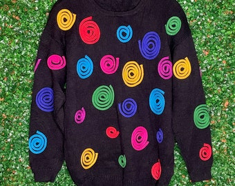 May include: Black sweater with colorful spiral designs. The sweater has a crew neck and long sleeves.