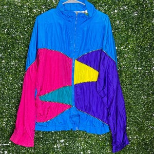 May include: A blue, pink, purple, yellow and green colour block windbreaker jacket with a zip closure.
