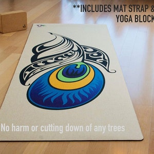 Może przedstawiać: Beżowa mata do jogi z kolorowym wzorem oka pawia. Tekst "INCLUDES MAT STRAP & YOGA BLOCK" jest nadrukowany na g&oacute;rze maty. Tekst "No harm or cutting down of any trees" jest nadrukowany na dole maty.