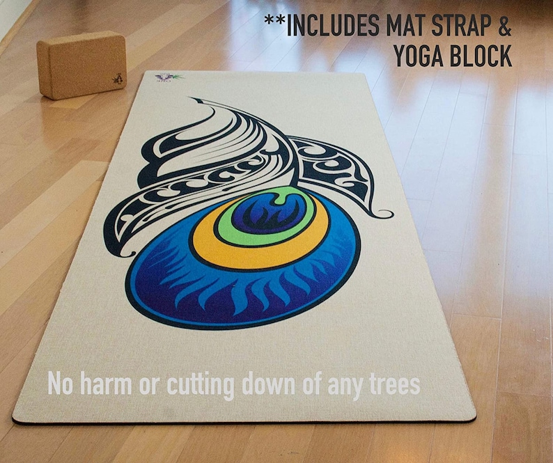 Może przedstawiać: Beżowa mata do jogi z kolorowym wzorem oka pawia. Tekst "INCLUDES MAT STRAP & YOGA BLOCK" jest nadrukowany na g&oacute;rze maty. Tekst "No harm or cutting down of any trees" jest nadrukowany na dole maty.