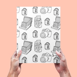 Puede incluir: Una ilustración en blanco y negro de un patrón repetido de cámaras y cartuchos de película. Los cartuchos de película están etiquetados con "400".