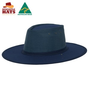 May include: A navy blue wide-brimmed hat with a textured fabric. The hat has a band around the crown and a small button on the top. The hat is made in Australia.