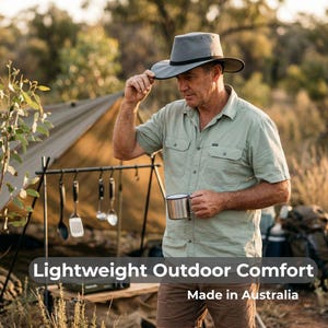 May include: A man wearing a grey outdoor hat and a light green shirt, holding a metal mug. The image includes the text "Lightweight Outdoor Comfort" and "Made in Australia". A camping tent and cooking utensils are visible in the background.