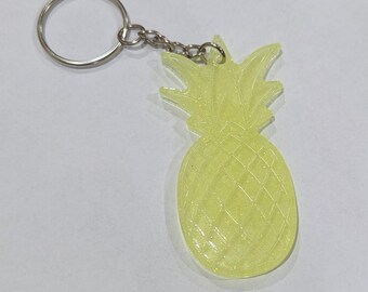 May include: A yellow pineapple-shaped keychain with a silver key ring and chain. The pineapple design has a textured surface and is a bright, eye-catching accessory. This tropical-themed keychain is perfect for adding a touch of fun to your keys or bag.
