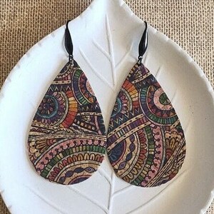 Op de afbeelding: Een paar traanvormige kurken oorbellen met een kleurrijk, ingewikkeld paisley-patroon. De oorbellen hebben zwarte haakjes.