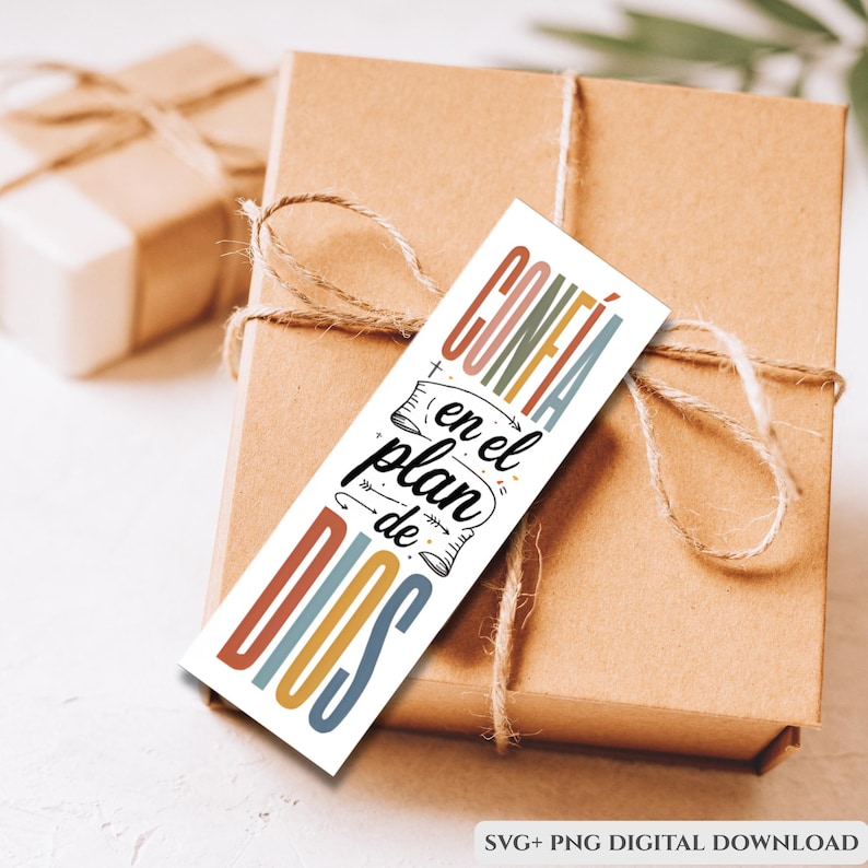 Puede incluir: Una caja de regalo marr&oacute;n atada con cuerda, con una etiqueta rectangular con el texto "CONF&Iacute;A en el plan de DIOS" en letras coloridas. La etiqueta es una descarga digital, como indica el texto en la parte inferior.