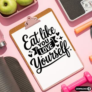 Może przedstawiać: Biała tablica z korkową podstawą i r&oacute;żowym klipsem. Tablica zawiera czarno-biały grafik z napisem "Eat like you love yourself" z wstążką i sercami.