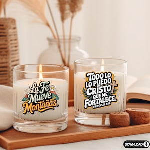 May include: Two lit glass candles with inspirational text. One candle reads "La Fe Mueve Monta&ntilde;as" with a mountain graphic. The other candle says "Todo lo puedo en Cristo que me fortalece" with a cross. Both candles sit on a wooden tray.