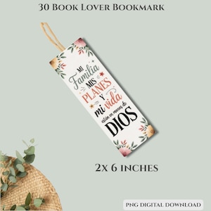 Puede incluir: Un marcap&aacute;ginas blanco con detalles florales y el texto "Mi Familia, Mis Planes y Mi Vida est&aacute;n en manos de DIOS." El marcap&aacute;ginas mide 5 x 15 cm y tiene una cuerda beige.