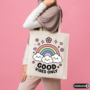 May include: A white tote bag with a rainbow, clouds, and flowers printed on it. The text "GOOD VIBES ONLY" is printed in black below the rainbow.