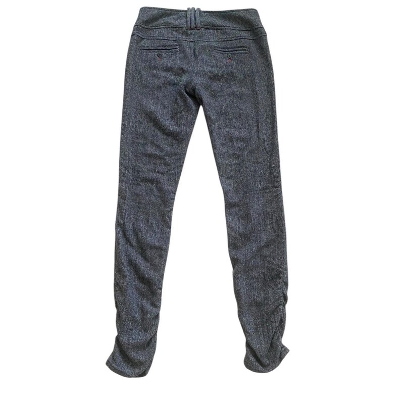 Op de afbeelding: Donkergrijze tweed broek met hoge taille en een getailleerde pasvorm. De broek heeft een knoop- en ritssluiting, riemlussen en zakken. De pijpen lopen taps toe naar een geplooid detail bij de enkels.