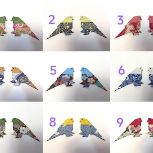 May include: Nine pairs of origami birds, each pair is a different color and pattern. The birds are numbered 1 through 9.