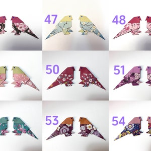 May include: Nine pairs of origami birds made from patterned paper. Each pair is numbered 46 through 54. The birds are in various colors and patterns, including pink, red, green, blue, and yellow.