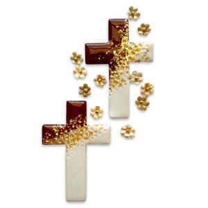 May include: Two decorative crosses with a white and brown color scheme, adorned with gold leaf accents. Small gold flower embellishments are scattered around the crosses, creating a delicate and elegant design. The crosses are set against a white background.