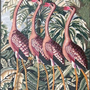 Puede incluir: Obra de arte en mosaico que representa cuatro flamencos rosas de pie en un exuberante entorno de jungla tropical verde. Los flamencos est&aacute;n dispuestos en l&iacute;nea, con la cabeza girada hacia el espectador. El fondo es de un verde vibrante con hojas de palmera y otros follajes tropicales.