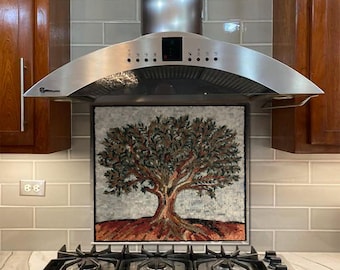 May include: A stainless steel range hood with a mosaic tile backsplash featuring a tree design. The backsplash is made of small, colorful tiles that create a unique and artistic look. The range hood has a sleek, modern design and is perfect for any kitchen.