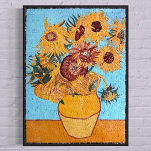 Può includere: Un'opera d'arte in mosaico che rappresenta un vaso pieno di girasoli. I girasoli sono gialli con centri marroni e sono disposti in un bouquet. Il vaso è giallo e ha una superficie testurizzata. Lo sfondo è di colore azzurro chiaro.