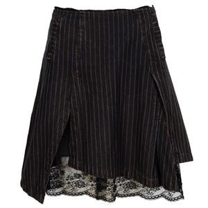 May include: A black and white striped skirt with a lace trim. The skirt is asymmetrical, with one side longer than the other.