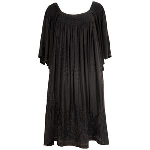 May include: A black midi dress with a square neckline and short, flowing sleeves. The dress features a textured pattern and a detailed floral design at the hem. The fabric drapes loosely, creating a relaxed silhouette.