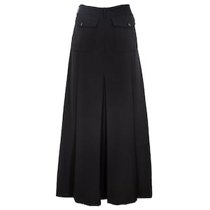 May include: A long, black skirt with a high waist and two front pockets. The skirt has a pleated design and falls to the floor. The fabric appears to be a smooth, solid material. The skirt is suitable for various occasions.