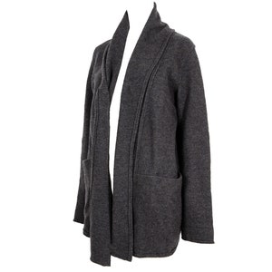 Op de afbeelding: Een antracietgrijze cardigan met een shawlkraag en twee zakken. De cardigan is gemaakt van een zachte, gebreide stof.