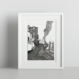 Puede incluir: Dibujo en blanco y negro de una calle adoquinada en una ciudad europea. La calle está bordeada de edificios a ambos lados, y hay un árbol en primer plano.