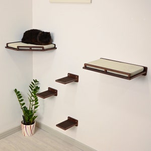 May include: A set of five wall-mounted cat shelves made of dark wood with beige cushions. The shelves are arranged in a staggered pattern, with the largest shelf at the top and the smallest shelf at the bottom. A black cat is lying on the top shelf.