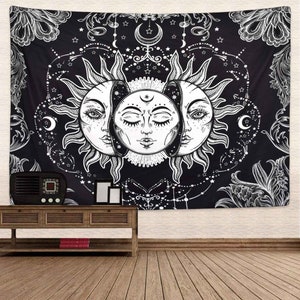 May include: Black and white tapestry featuring a stylized sun with two faces, surrounded by stars and floral designs.