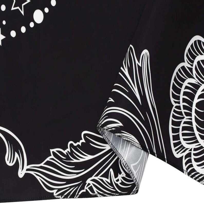 May include: Black fabric with a white floral pattern. The fabric has a white border and a white seam.