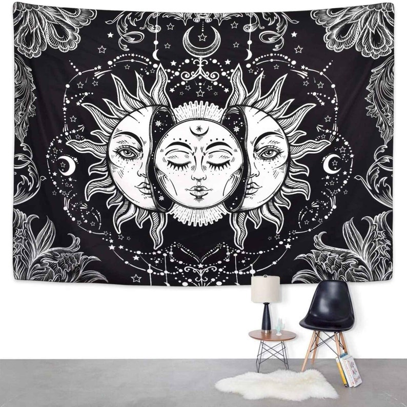 May include: Black and white tapestry featuring a sun and moon design with intricate details. The sun and moon are depicted with faces and surrounded by stars and floral patterns.