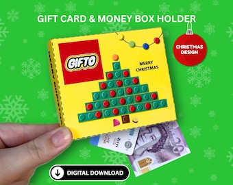 Puede incluir: Un soporte para tarjetas de regalo y dinero amarillo y rojo con un diseño de árbol de Navidad. La caja tiene un logotipo rojo que dice "GIFTO" y el texto "Feliz Navidad". La caja está decorada con una cadena de luces de colores y una bola de Navidad.