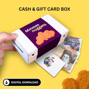 May include: A white and purple box labeled "Mmmm nuggets" with a cluster of orange nuggets on top. The box is open, revealing cash and a gift card. The text "CASH & GIFT CARD BOX" is at the top.